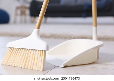 Cleaning broom and dustpan on wooden floor indoors - Powered by Shutterstock