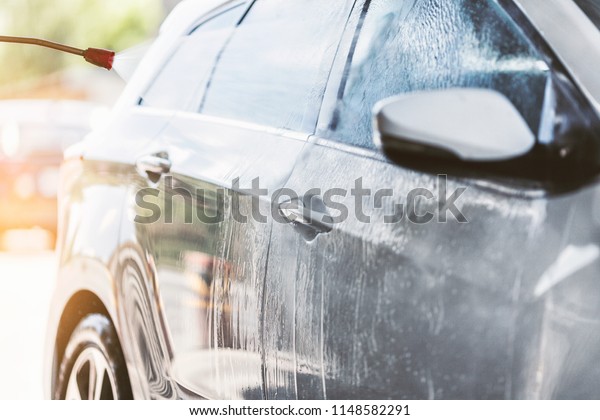 Cleaning\
the car with the high pressure car wash\
washer