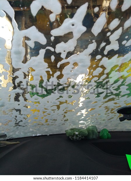 Cleaning a car Soap leaks on the window of the car\
whit foam \
