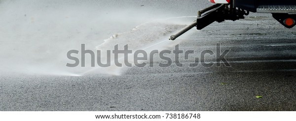 Cleaning car spray water\
on asphalt road 