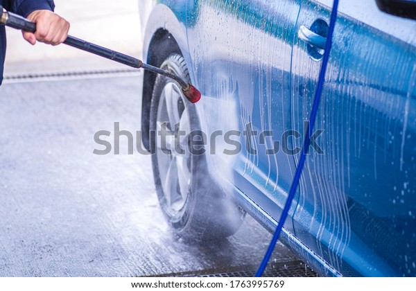 Cleaning Car Using High\
Pressure Water.Manual car wash with pressurized water in car wash\
outside.
