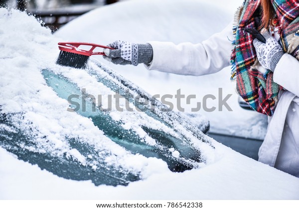 Cleaning\
car window from snow. Scraping ice from\
window