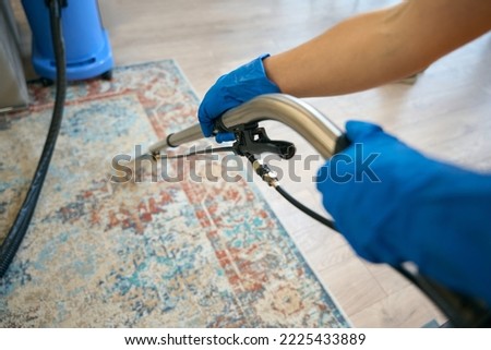 Cleaning company worker cleans the carpet in a recreation area