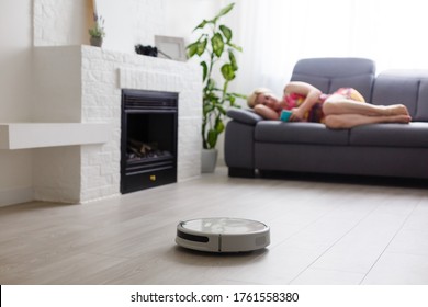 Cleaning Concept - Automatic Robotic Hoover Clean The Room While Woman Relaxing Close Up