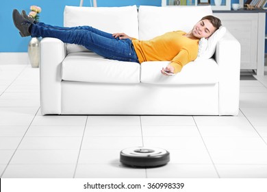 Cleaning Concept - Automatic Robotic Hoover Clean The Room While Man Relaxing, Close Up