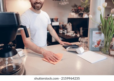 Cleaning Counter At Cafeteria Concept. Male Barista Working At Bar And Keep It Clean. Close Up.