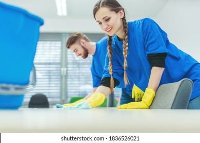 Cleaning Crew Wiping Desks In An Office Building