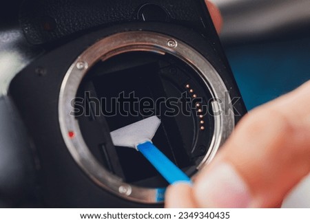 Cleaning dirty camera sensor. Digital photo camera with cleaning tools