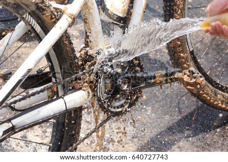 Cleaning a dirty mountain bike covered with mud and dirt