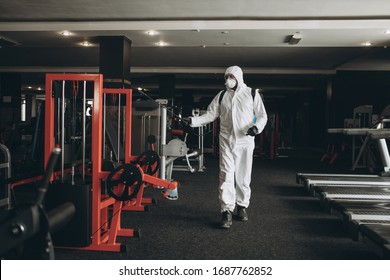 Cleaning And Disinfection In Crowded Places Amid The Coronavirus Epidemic Gym Cleaning And Disinfection Infection Prevention And Control Of Epidemic. Protective Suit And Mask And Spray Bag