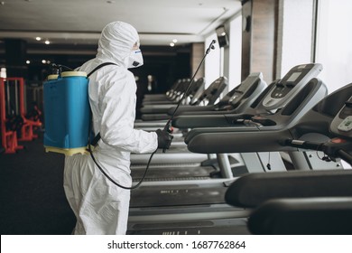 Cleaning and Disinfection in crowded places amid the coronavirus epidemic Gym cleaning and disinfection Infection prevention and control of epidemic. Protective suit and mask and spray bag - Shutterstock ID 1687762864