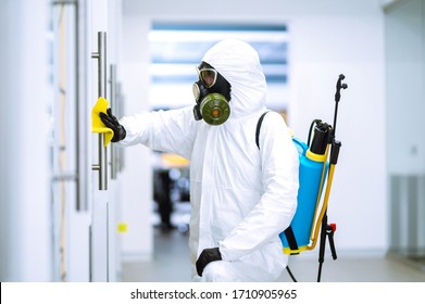 Cleaning and disinfection of office to prevent COVID-19, Man in protective hazmat suit washes office furniture to preventing the spread of coronavirus, pandemic in quarantine city.