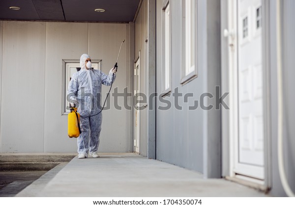 Cleaning and Disinfection outside around buildings,\
the coronavirus epidemic. Professional teams for disinfection\
efforts. Infection prevention and control of epidemic. Protective\
suit and mask.