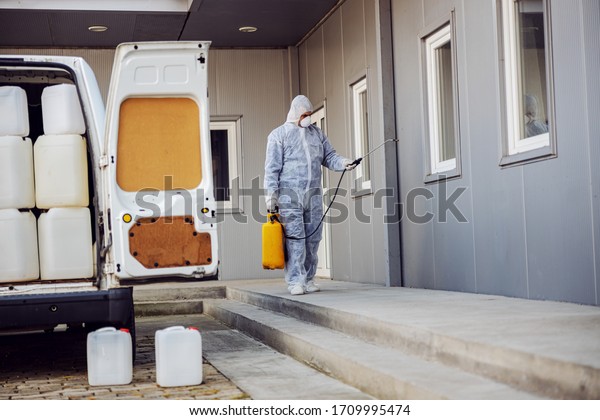 Cleaning and Disinfection outside around buildings,\
the coronavirus epidemic. Professional teams for disinfection\
efforts. Infection prevention and control of epidemic. Protective\
suit and mask.