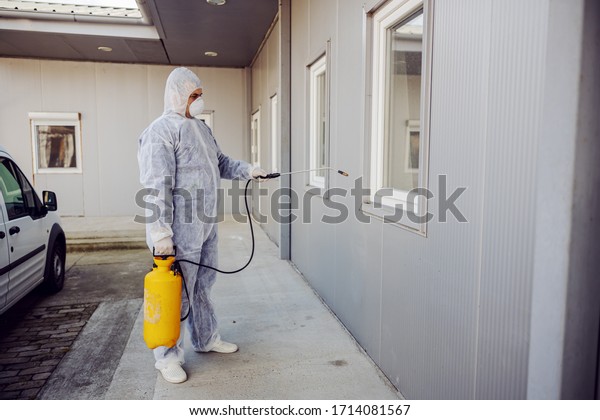 Cleaning and Disinfection outside around buildings,
the coronavirus epidemic. Professional teams for disinfection
efforts. Infection prevention and control of epidemic. Protective
suit and mask.