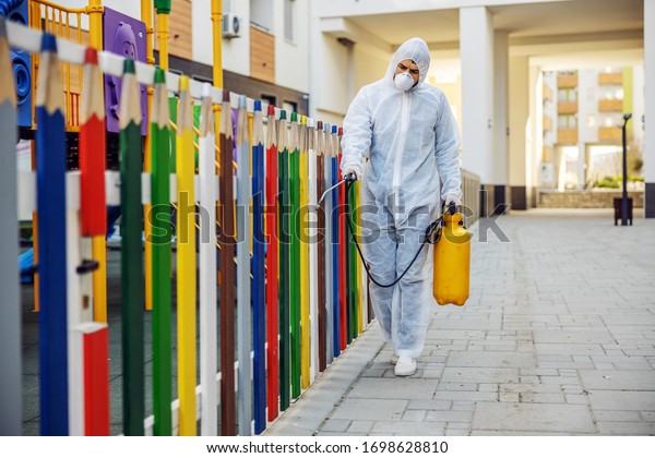 Cleaning and Disinfection outside around\
kindergarten, the coronavirus epidemic. Professional teams for\
disinfection efforts. Infection prevention and control of epidemic.\
Protective suit and\
mask.