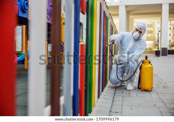 Cleaning and Disinfection outside around\
kindergarten, the coronavirus epidemic. Professional teams for\
disinfection efforts. Infection prevention and control of epidemic.\
Protective suit and\
mask.