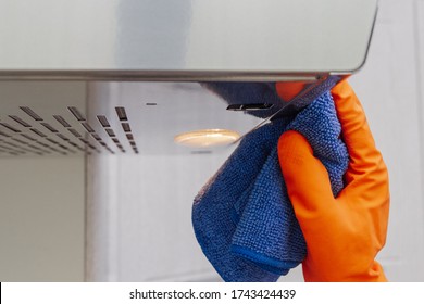 Cleaning domestic cooker hood. Women's hands clean the kitchen hood with a cloth