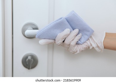 Cleaning Door Handle With Blue Wipe In White Gloves. Sanitize Surfaces Prevention In Hospital And Public Spaces Against Corona Virus. Woman Hand Using Towel For Cleaning Home Room Door Link.