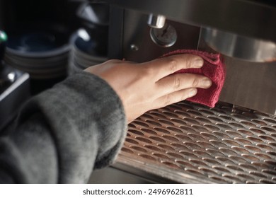 Cleaning up espresso machine with red micro fibre cloth in coffee shop - Powered by Shutterstock