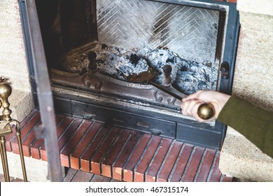 Cleaning The Fireplace. Hand Of Man Holding A Brass Shovel With Ash
