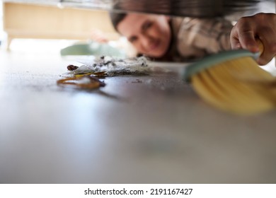 Cleaning The Floor, Doing Chores And Sweeping Dust Or Dirt From Under A Bed. Domestic Worker, Maid Or Stay At Home Mom Using A Broom, Housework And Hygiene Equipment To Keep A Clean House