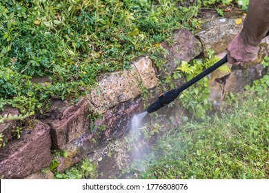 Cleaning Of A Garden Sandstone Wall With A High-pressure Cleaner