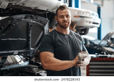 Cleaning, hands and portrait of mechanic in workshop with car service, maintenance or auto insurance. Cloth, engine and proud man in garage for oil change, motor repair or vehicle quality assurance - Powered by Shutterstock