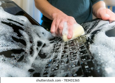 Cleaning the hard drive concept. Washing the laptop with dish soap.Also a symbol for making a big mistake!