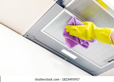 Cleaning the house. Washing kitchen hood, hand in glove clean aluminium filters. Clear extractor without fat.
