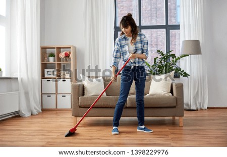 cleaning housework and housekeeping concept - happy asian woman with broom sweeping floor and dancing at home