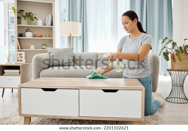 Cleaning, hygiene and house task with a woman\
spring cleaning, sanitize living room furniture. Young female wipe\
and dust, enjoying fresh routine housework in a modern, germ free\
living space