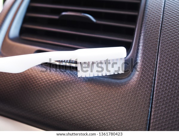 Cleaning inside the car by using a\
toothbrush at channel of air\
conditioning
