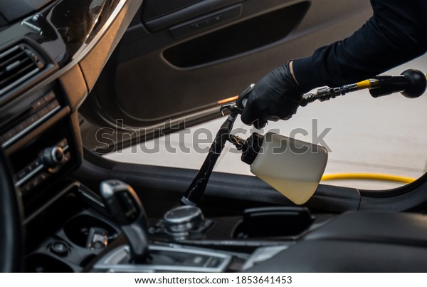 cleaning the interior\
car with black gloves 