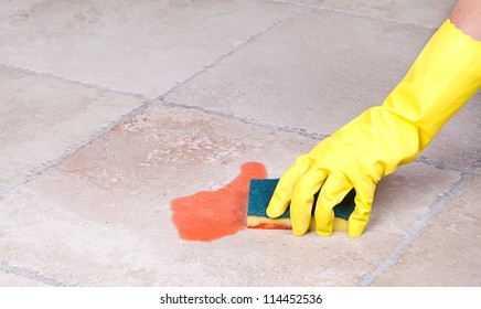 Cleaning Up Juice Spill  On Tile Floor With Sponge