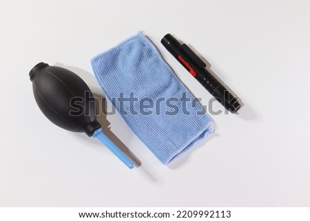 cleaning kit (rubber air blower, lens pen and cloth) on a white background. Used to clean dust on digital cameras and others