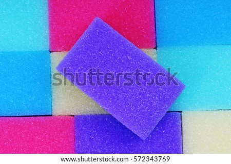 Cleaning kitchen sponge texture as background. Colorful yellow pink green purple blue multicolor sponges. Close up macro about sponges. Sponge pattern textures concept background wallpaper material.