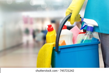 Cleaning lady with a bucket and cleaning products on blurred background.
