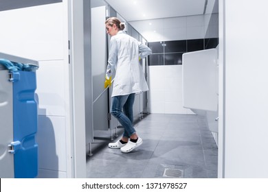 Cleaning Lady Or Janitor Mopping The Floor In Restroom Cleaning The Stall 