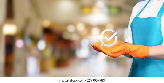 Cleaning Lady Shows A Badge Of A Job Well Done You On A Blurred Background.