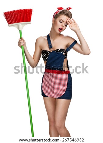 Cleaning lady standing unhappy after spring cleaning with broom. Photo of young beautiful American pin-up girl isolated on white background. Cleaning service concept
