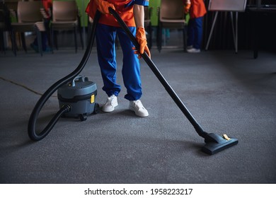 Cleaning Lady Using A Canister Vacuum Cleaner