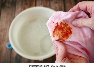 Cleaning Laundry Manually. Women's Hands In Gloves Washing Dirty Stained On Colored Cloth With A Stain Remover And Soak In Soapy Water, Closeup