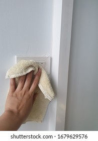 Cleaning The Light Switch With A Towel.