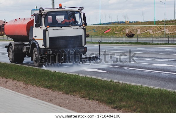 Cleaning machine washes asphalt road surface the\
city street,