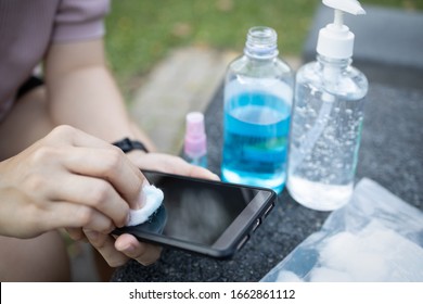 Cleaning mobile phone to eliminate germs,Covid-19
hands of asian woman cleaning the phone by hand sanitizer gel,girl using cotton wool with alcohol to wipe to avoid contaminating with Corona virus - Powered by Shutterstock