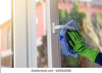 Cleaning of opened vinyl plastic window. Protective glove on hand and cleaning cloth