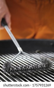 Cleaning Outdoor Charcoal  Grill With A Metal Brush Before Next Grilling. Close-up. Vertical Image.