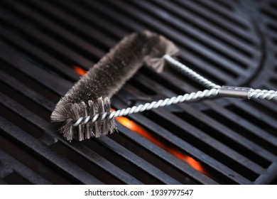 Cleaning Outdoor Gas Grill With A Metal Brush Before Next Grilling. Close-up. 