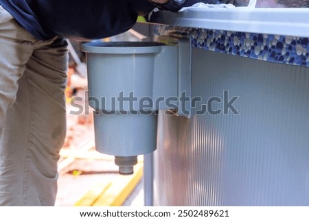 Cleaning of pool surface from dirt, trash debris with pool skimmer basket installed on frame that collects dirt trash
